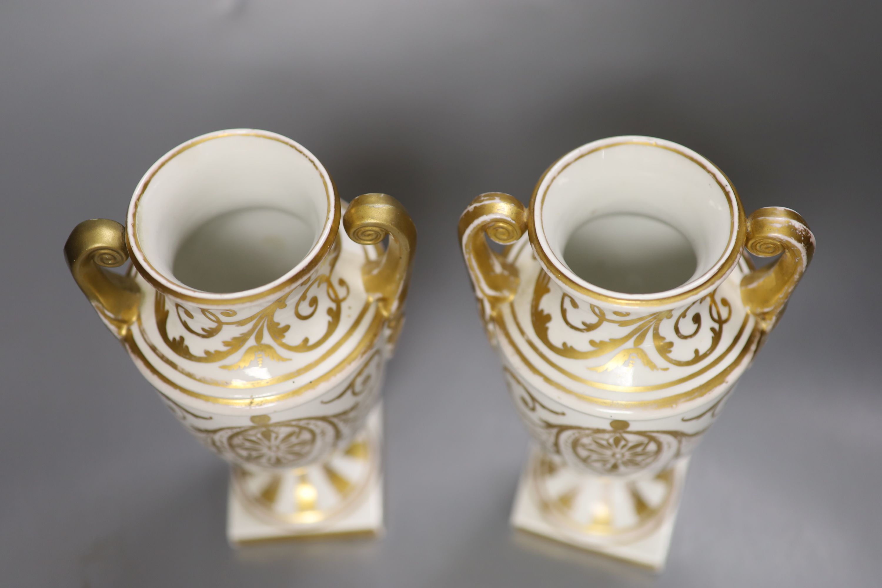 A pair of Regency porcelain two handled vases, painted with flowers, height 19cm